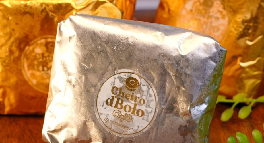 Bolo embalado em papel metalizado com a etiqueta da Cheiro d'Bolo